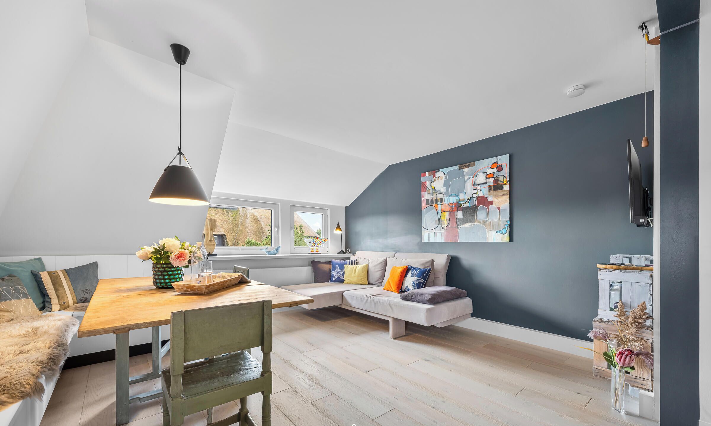 Un loft moderne comprenant un espace repas, un coin salon et une grande fenêtre.
