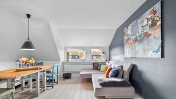 Ein modernes Loft mit Essbereich, einer Couch und einem großen abstrakten Gemälde.