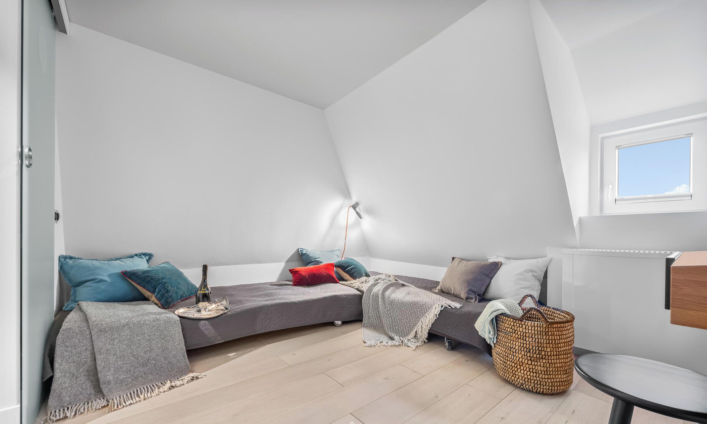 Un cuarto estilo loft con techo curvo, una mesita, una cesta tejida y una lámpara.
