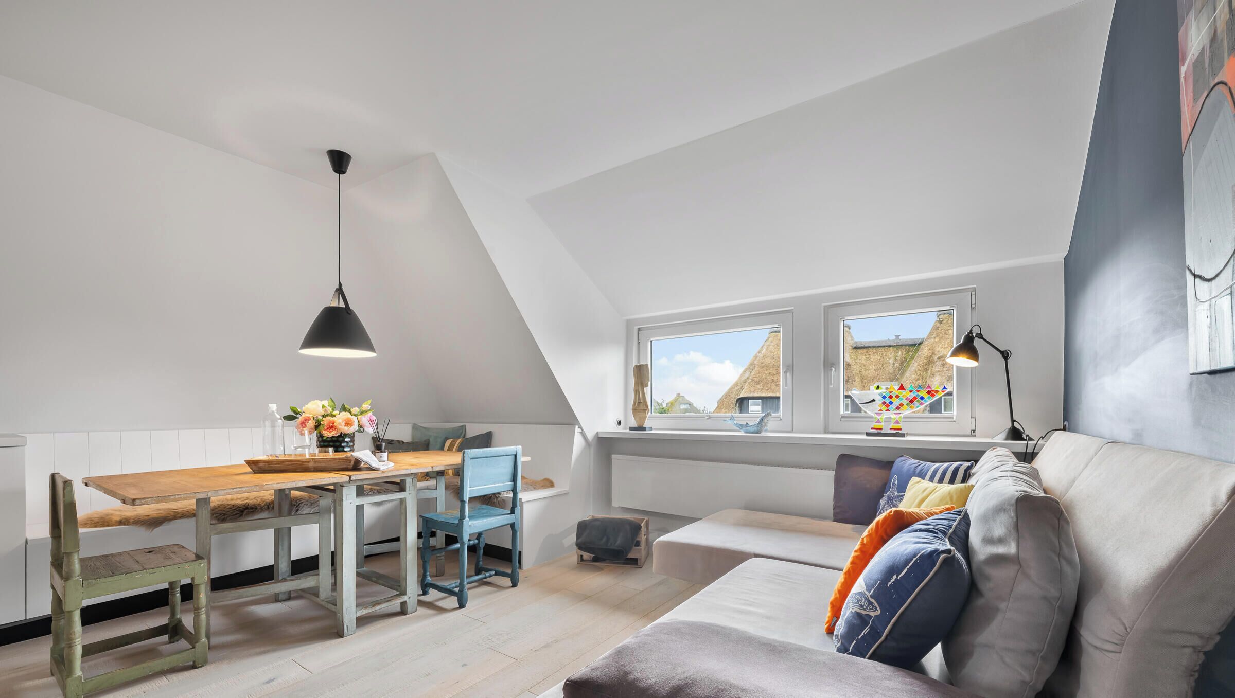Ein Loft-Zimmer mit Essbereich, einer Couch und einem Fenster mit Blick auf Gebäude.