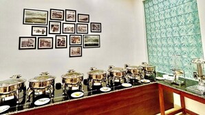 Un salón de conferencias con una larga mesa, cuadros en la pared y una ventana con diseño.