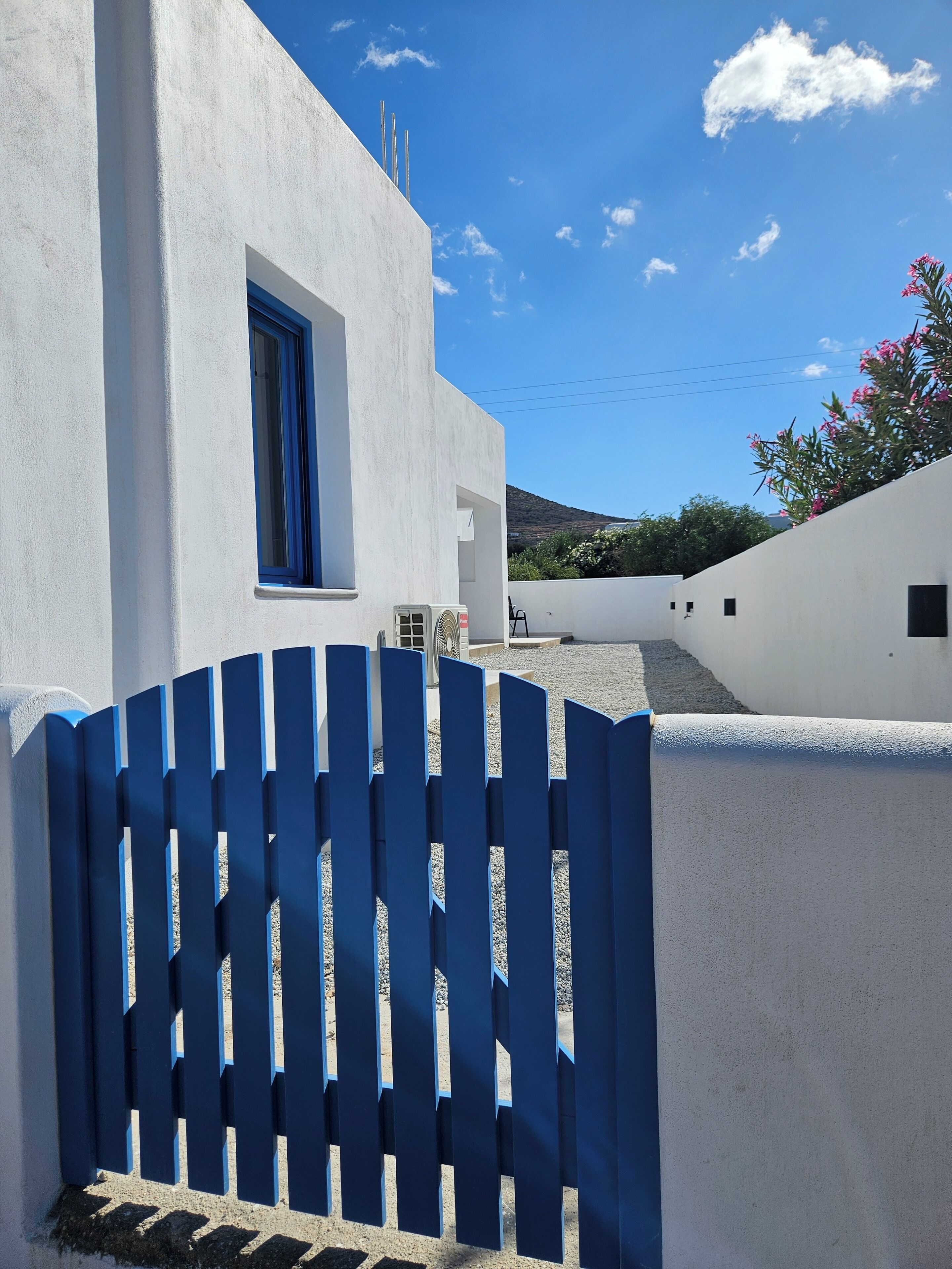Un edificio blanco con una puerta azul y una ventana.