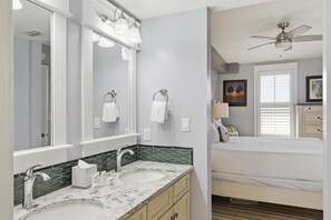 A bathroom with two sinks, a large mirror, and a ceiling fan. - One Bedroom Condo at Grand Sandestin (Miramar Beach)