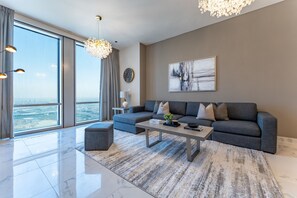 Ein modernes Wohnzimmer mit grauem Sofa, einem Couchtisch und einem großen Fenster mit Blick auf die Stadt.