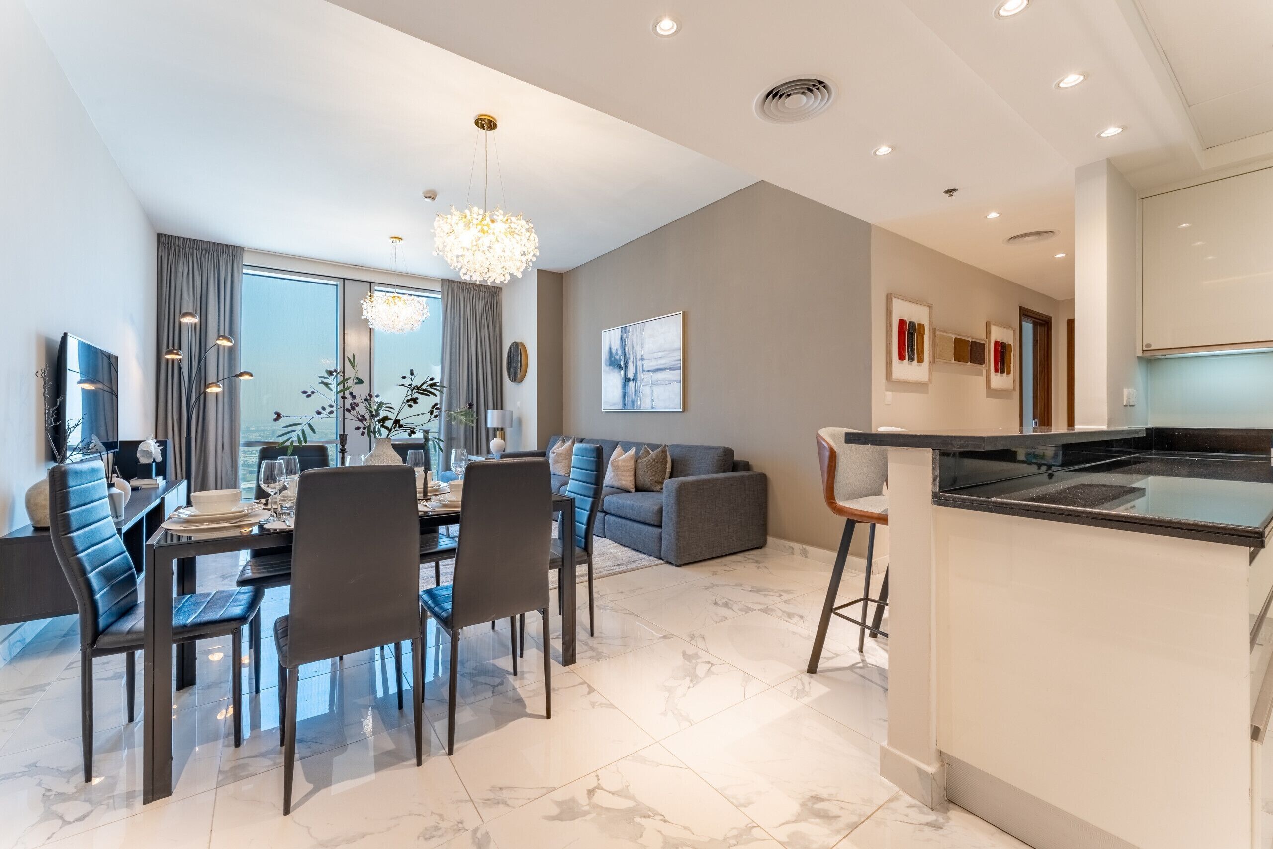 Een moderne woonkamer met een eethoek, een kookeiland en een groot raam.