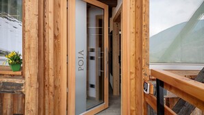 A wooden exterior of a building with a glass door labeled 'POJA' and a keypad lock. - Apartment 'Loni Lodge Poja' (Vermiglio)