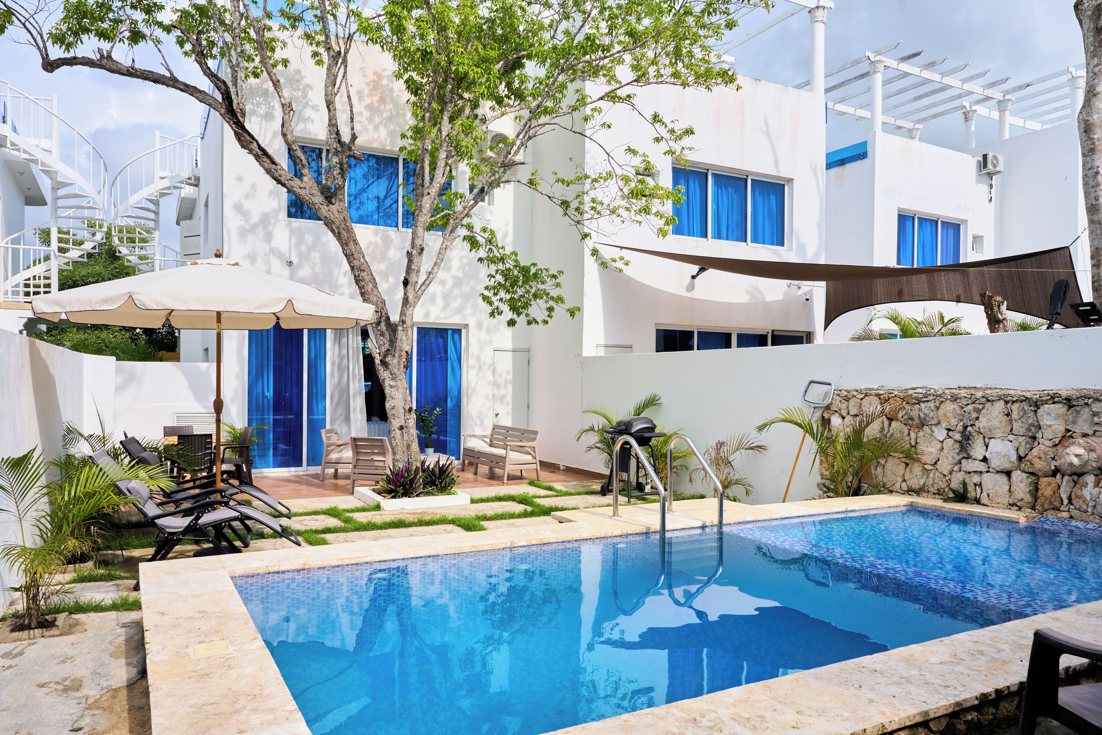 Een buitenzwembad, parasols voor strand/zwembad