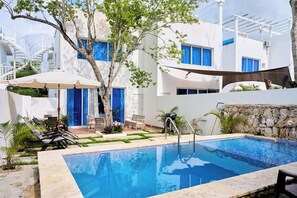 Een buitenzwembad, parasols voor strand/zwembad