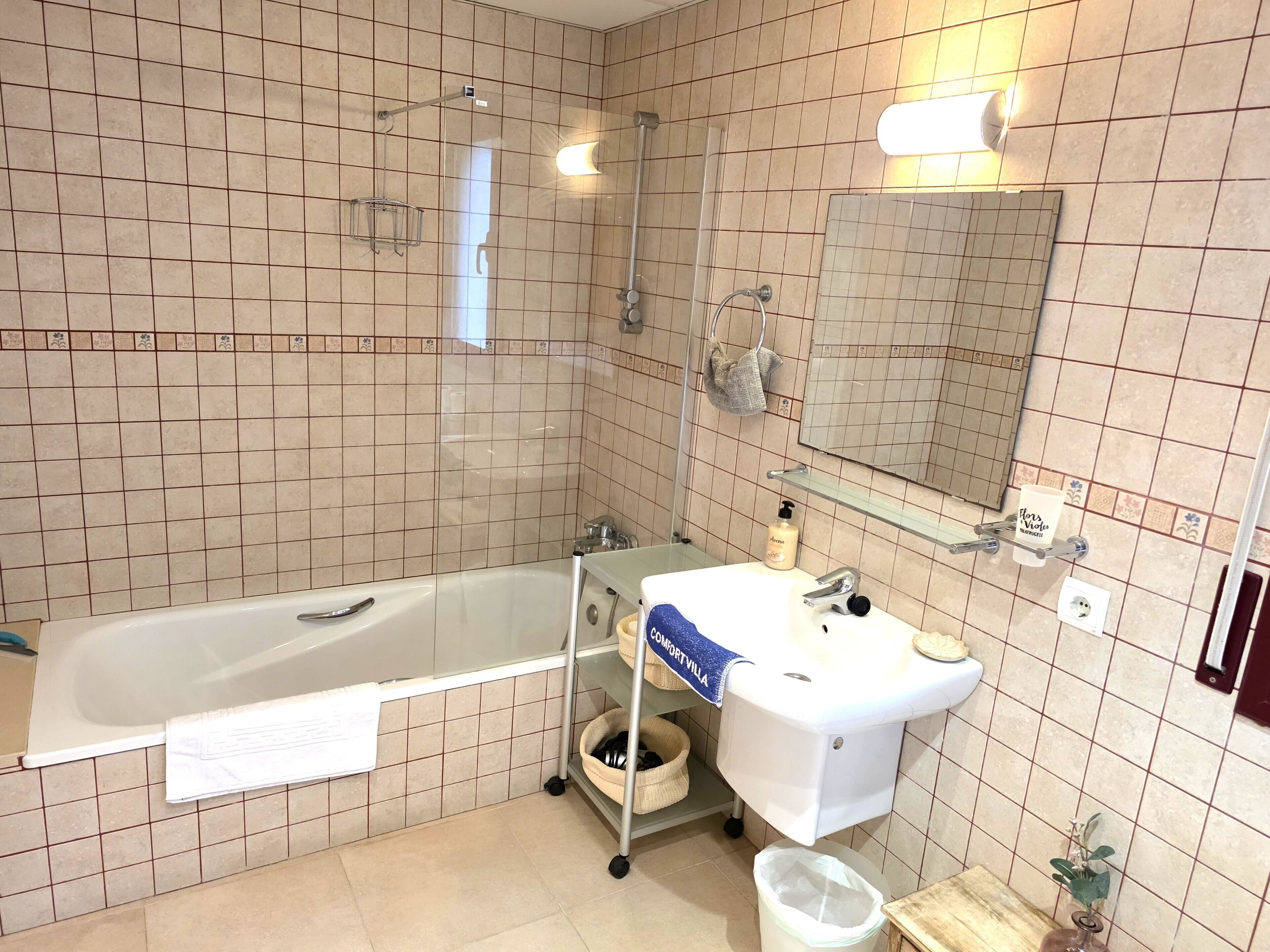A bathroom with a bathtub, a sink, a mirror, and a shower.