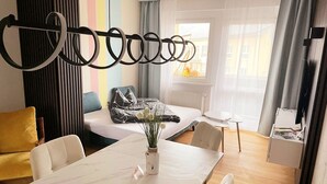 A modern hotel room with a bed, a dining table, and a small desk. - Beautiful art deco apartment (Sehmatal)