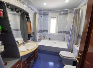 Une salle de bain avec une baignoire, des toilettes et un lavabo.