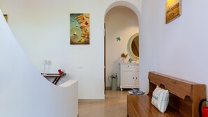 Ein Flur mit einer hölzernen Bank, einem weißen Schrank und einem Bild an der Wand.