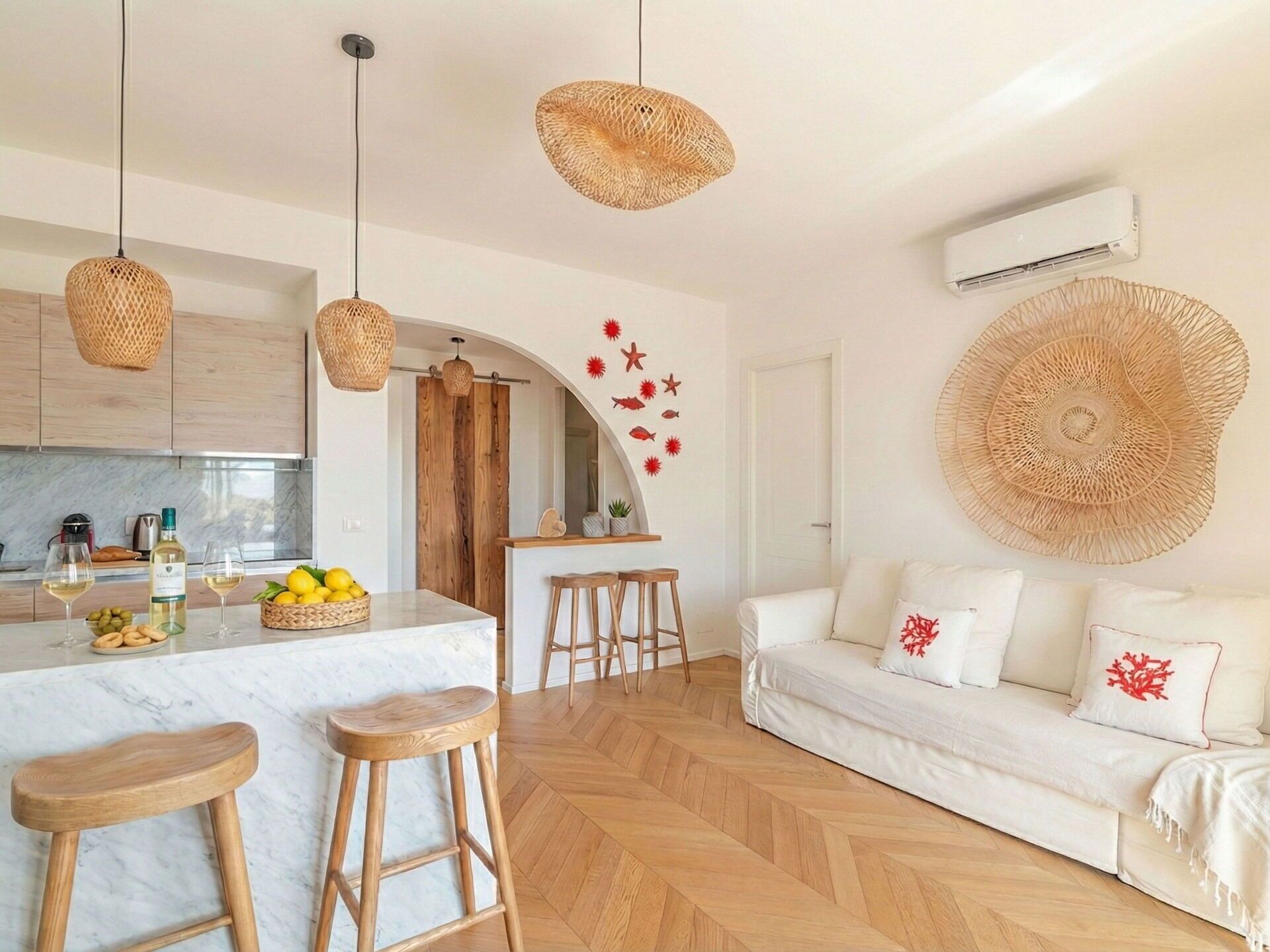 A modern kitchen with a marble countertop, wooden stools, and a central island.