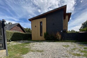 Ein modernes, zweistöckiges Haus mit Holzfassade und dunklem Metallanstrich.