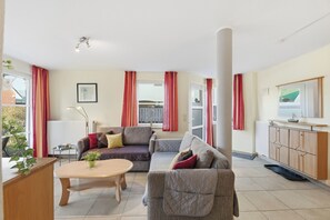 Un salon comprenant un canapé, une table basse, un radiateur et un meuble.