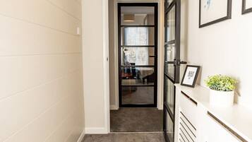 A hallway with a carpeted floor, a white radiator, and a framed picture on the wall.