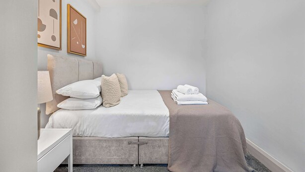 Ein modernes Schlafzimmer mit einem Bett, einem Nachttisch und einer Lampe.