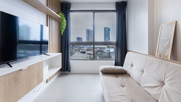 A modern living room with a flat-screen TV, a sofa, and a large window with a city view. - Parque Shopping #304 - Exclusive Apto by Carpediem (Recife)