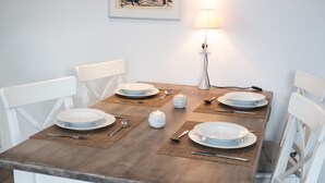 Taula de dinar posta amb plats, coberts i una espelma.
