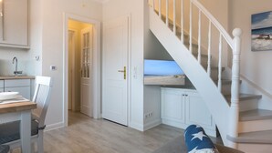 A modern interior with a staircase, a dining area, and a view through a door. - Comfort. House 55 Grad Nord with balcony and modern furnishings in Wenningstedt (Wenningstedt)