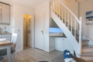 A modern interior with a staircase, a dining area, and a view through a door. - Comfort. House 55 Grad Nord with balcony and modern furnishings in Wenningstedt (Wenningstedt)