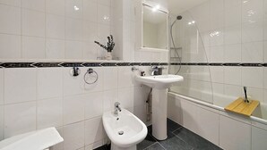 A modern bathroom with a bidet, a sink, and a shower. - Hertford Flat 12 (London)