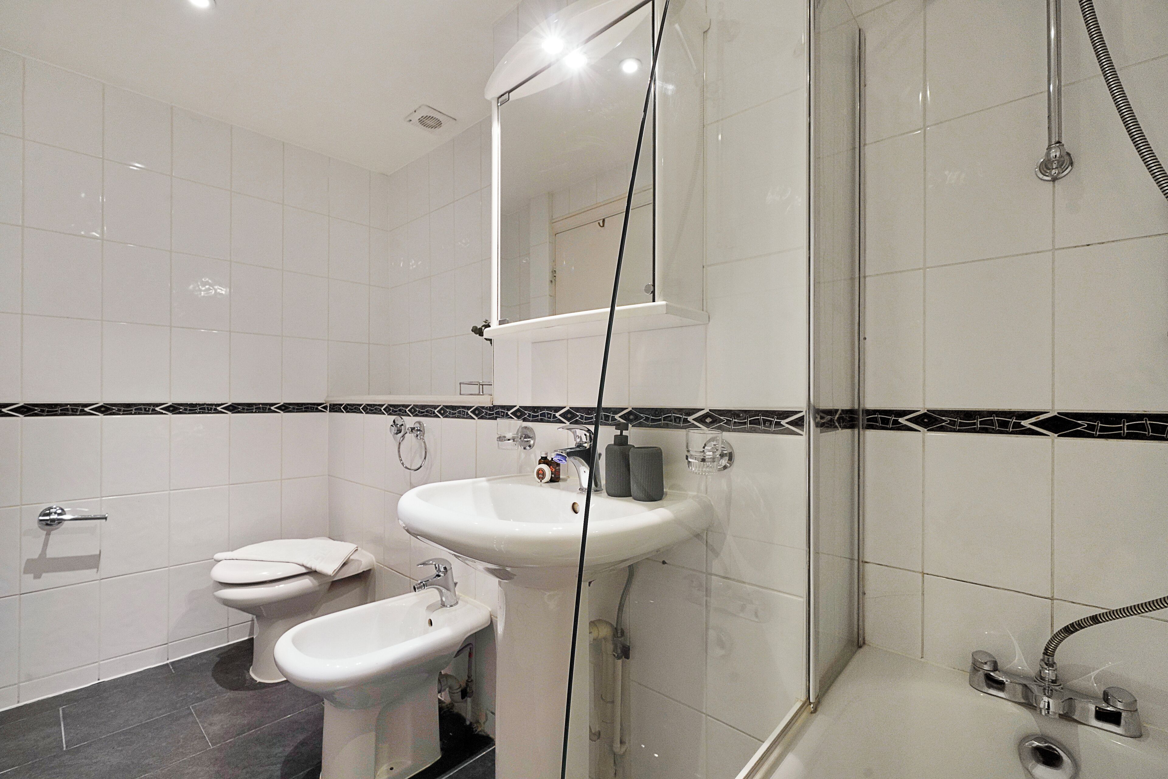 Ein modernes Badezimmer mit Toilette, Bidet, Waschbecken und Dusche.
