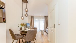 A modern dining area with a round table, four chairs, and hanging pendant lights. - This beautiful and new terraced house is centrally located in Westerland (Westerland)