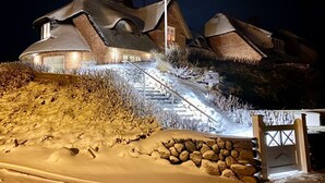 Ein schneebedecktes Gebäude mit einzigartiger Architektur, das eine steile Treppe zum Eingang aufweist.
