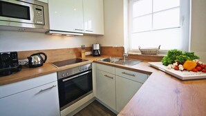 Een moderne keuken met roestvrijstalen apparatuur, houten aanrecht en een raam dat voor natuurlijk licht zorgt.