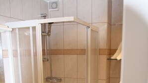 Ein Badezimmer mit Duschkabine, Waschbecken und Toilette.