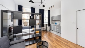 Un salon moderne avec un canapé, une table basse en verre et une bibliothèque intégrée.