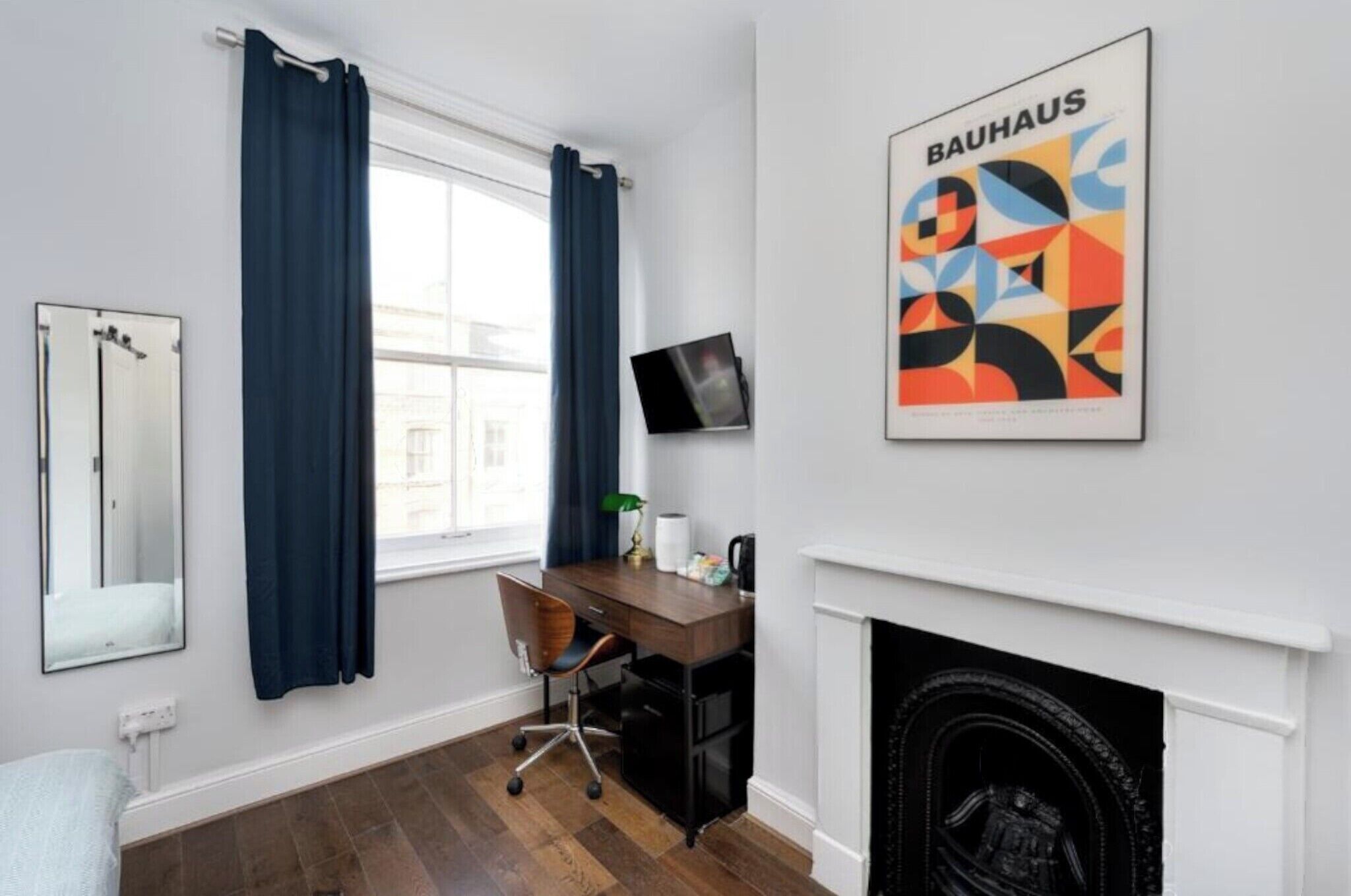 Una habitación moderna con escritorio, silla y chimenea.
