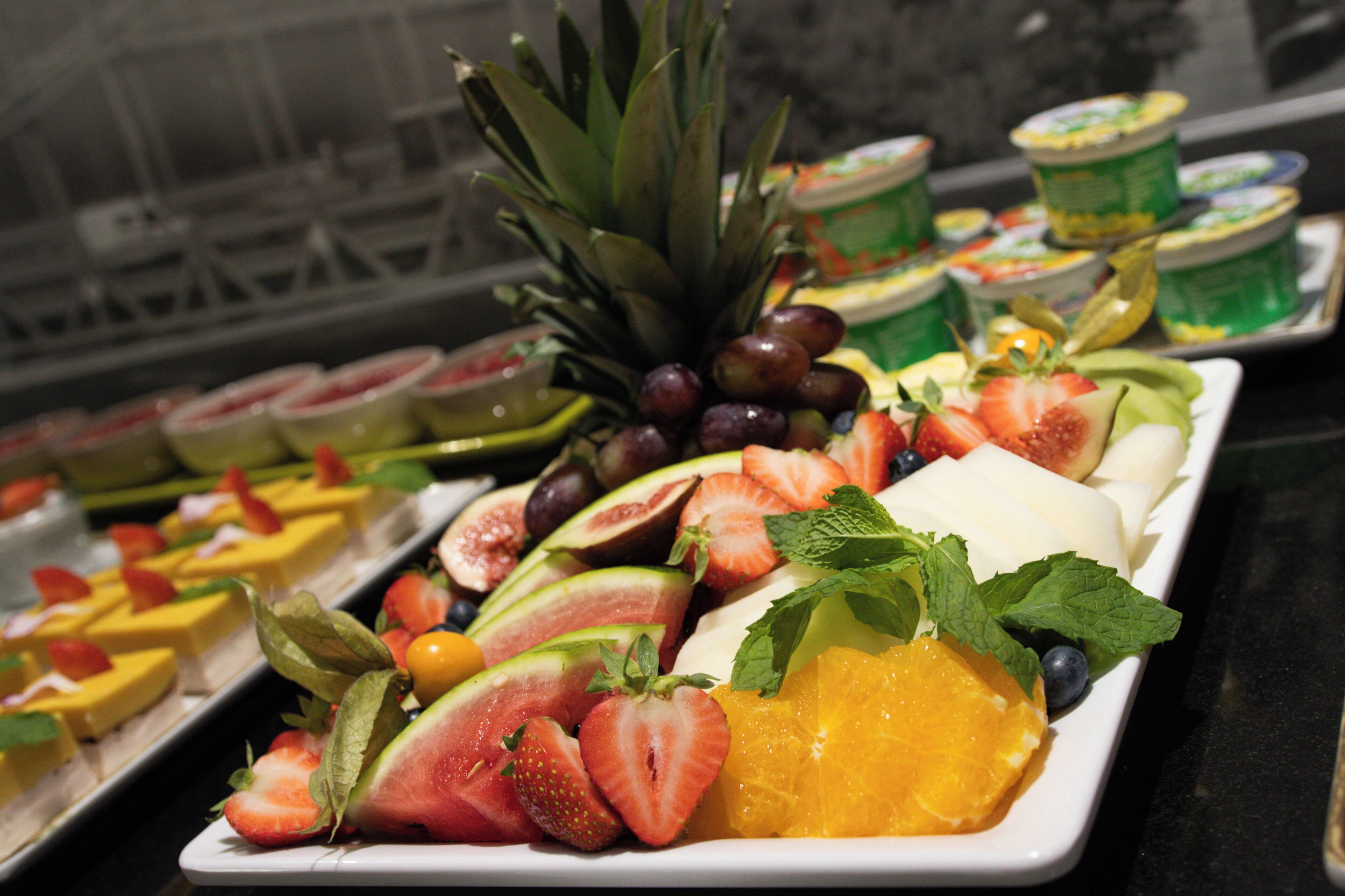 A buffet with various fruits and desserts.