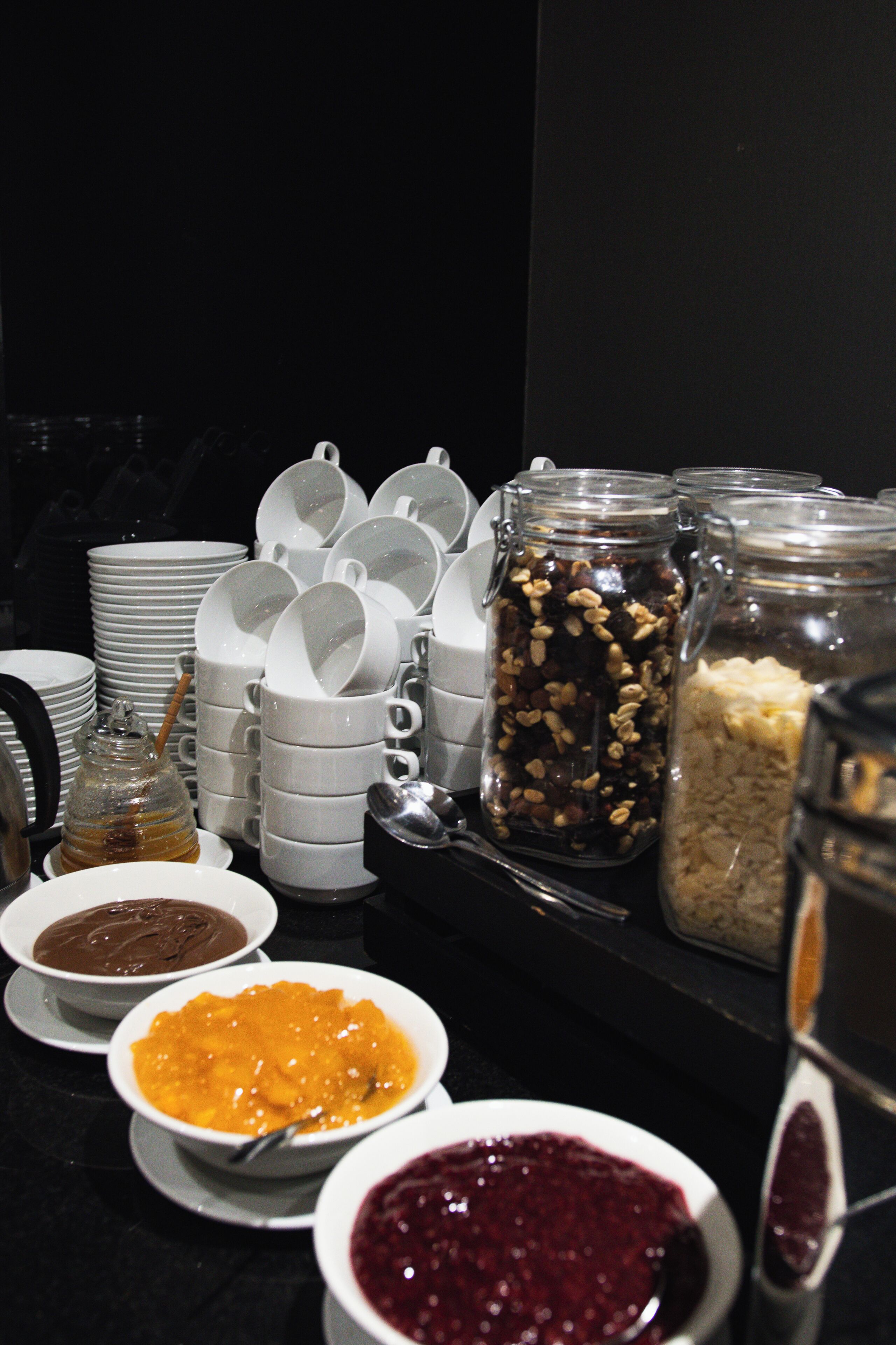 A buffet table with various food items and utensils.