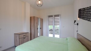 Una camera da letto con un letto, un armadio e una porta che dà su uno spazio esterno.