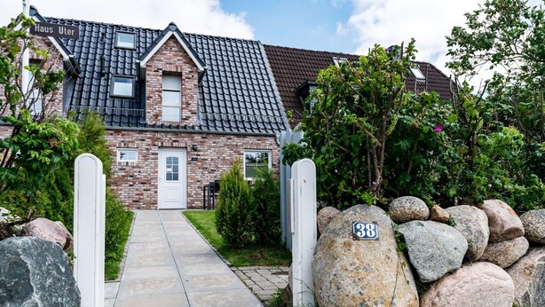 A brick house with a tiled roof, a front door, and a pathway leading to it. - Beautiful house Uter with terrace and modern furnishings in Westerland (Westerland)