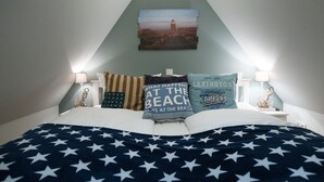 Ein Schlafzimmer mit einem Bett, Kissen und einem Bild an der Wand.