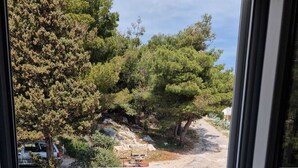 A balcony with a view of trees and a rocky landscape. - Cozy vacation apartment in Smokvica, island of Pag, Dalmatia, Croatia - close to the beach (Smokvica Pag)