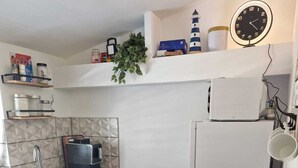 A compact kitchen with a wooden table, a sink, a kettle, and a microwave. - Cozy vacation apartment in Smokvica, island of Pag, Dalmatia, Croatia - close to the beach (Smokvica Pag)