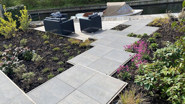 Une terrasse avec des meubles d’extérieur et un quai pour bateaux.