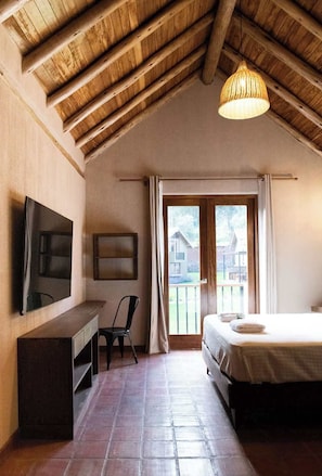 A bedroom with a wooden ceiling, a bed, a desk, a chair, and a TV. - w Spacious 3BR Villa in Sacred Valley (Calca)