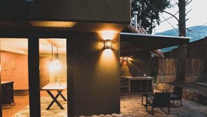 Un espace de restauration extérieur accueillant, doté d’un sol en pierre et de mobilier en bois.