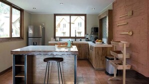 Une cuisine moderne dotée d’un îlot central, de meubles en bois et d’une grande fenêtre.