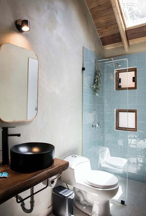 A modern bathroom with a round black sink, a white toilet, and a glass-enclosed shower. - w Serene 2BR Riverside Villa w Nature Views (Calca)
