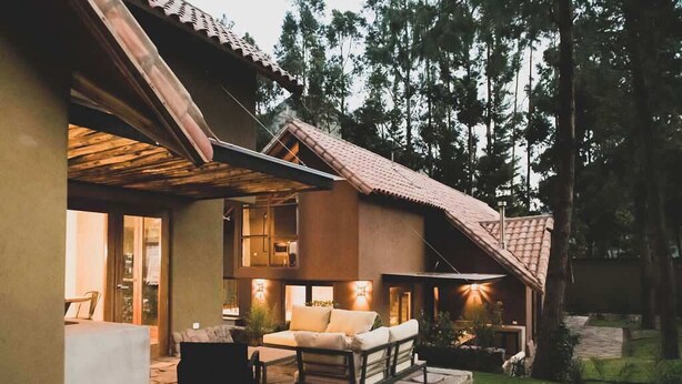 A modern house with a patio area featuring outdoor furniture and a fireplace. - w Peaceful 2BR Riverside Villa in Sacred Valley (Calca)