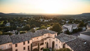 A residential area with traditional architecture, including buildings with tiled roofs and arched doorways. - House in Pont Royal With Water Park Fun (Mallemort)