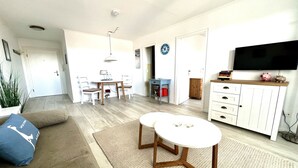 A modern living room with a sofa, coffee table, and TV stand. - Comfortable apartment with balcony, elevator and parking space in Westerland (Westerland)