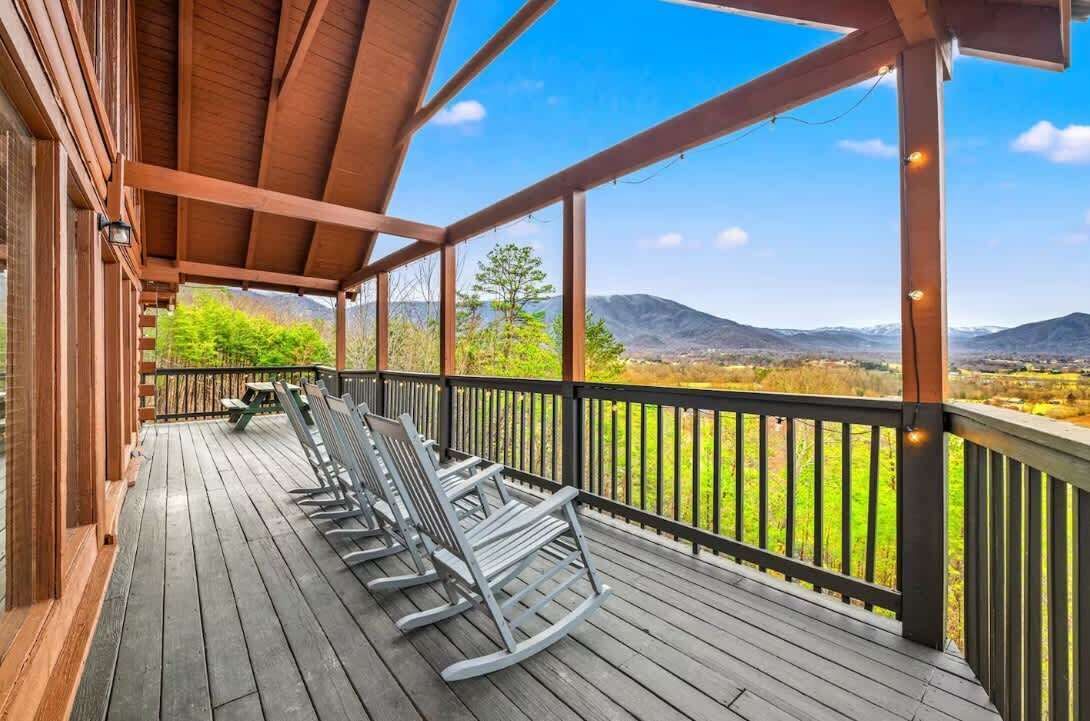 Eine Holzterrasse mit Schaukelstühlen und Blick auf Berge.