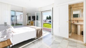 Une chambre d’hôtel moderne équipée d’un lit, d’une télévision, d’une salle de bain avec un lavabo et une douche, et offrant une vue sur l’extérieur.